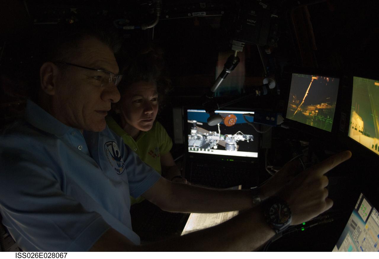 ISS026-E-028067 (18 Feb. 2011) --- European Space Agency astronaut Paolo Nespoli and NASA astronaut Catherine (Cady) Coleman, both Expedition 26 flight engineers, operate the Canadarm2 controls inside the International Space Station?s Cupola to relocate the Japanese Kounotori2 H-II Transfer Vehicle (HTV2) from the Harmony node nadir port to Harmony?s zenith port.