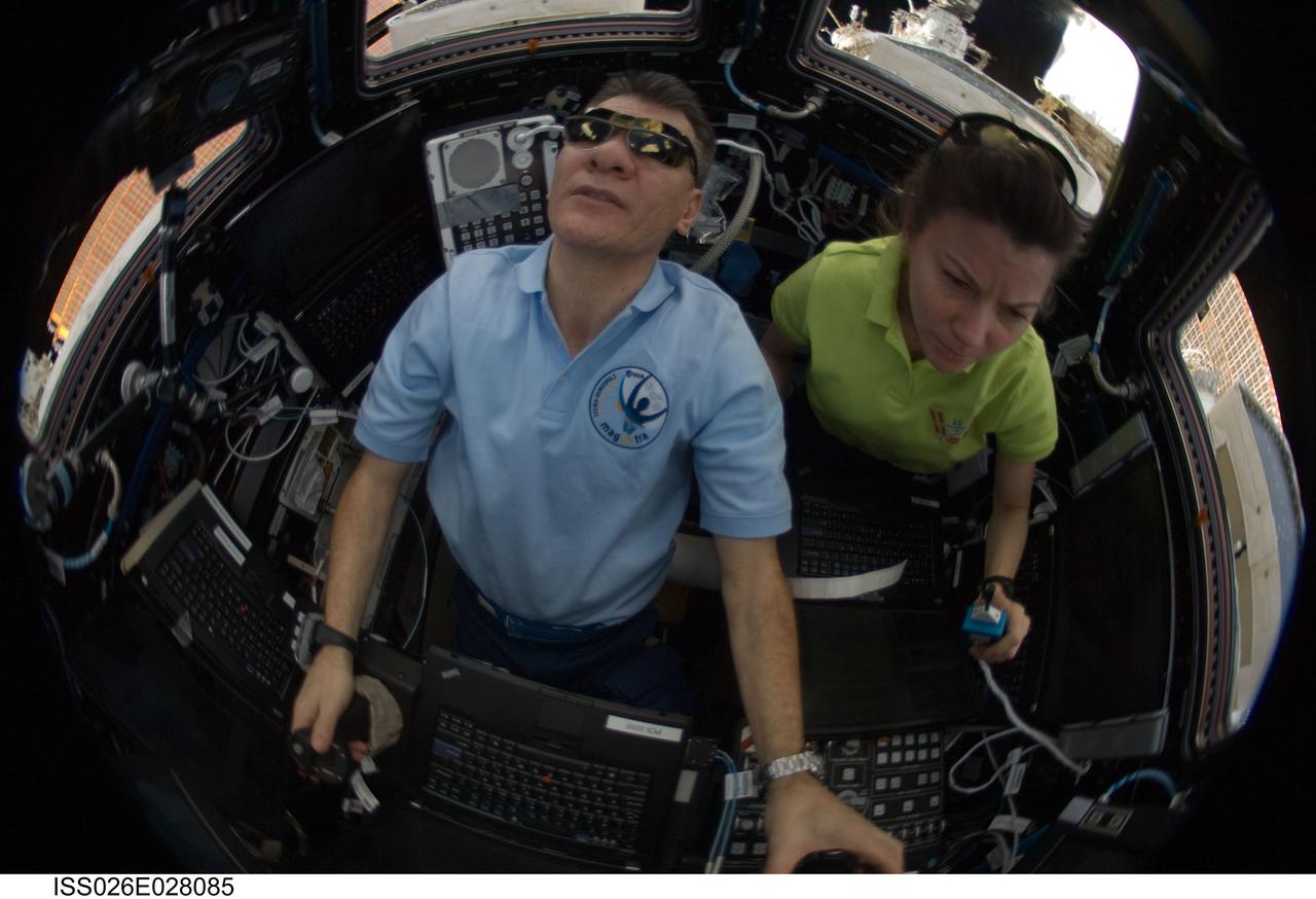 ISS026-E-028085 (18 Feb. 2011) --- European Space Agency astronaut Paolo Nespoli and NASA astronaut Catherine (Cady) Coleman, both Expedition 26 flight engineers, operate the Canadarm2 controls inside the International Space Station?s Cupola to relocate the Japanese Kounotori2 H-II Transfer Vehicle (HTV2) from the Harmony node nadir port to Harmony?s zenith port.