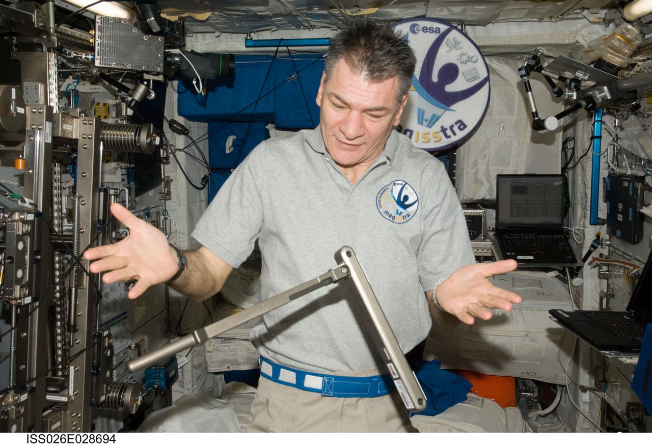 ISS026-E-028694 (22 Feb. 2011) --- European Space Agency astronaut Paolo Nespoli, Expedition 26 flight engineer, is pictured with a can crusher tool floating freely in the Columbus laboratory of the International Space Station. The tool was built by the High school students United with NASA to Create Hardware (HUNCH).