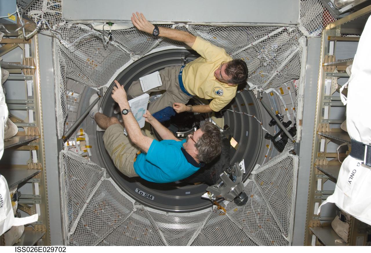 ISS026-E-029702 (25 Feb. 2011) --- European Space Agency astronaut Paolo Nespoli (top) and Russian cosmonaut Alexander Kaleri, both Expedition 26 flight engineers, work in the newly-attached European Space Agency's "Johannes Kepler" Automated Transfer Vehicle-2 (ATV-2) of the International Space Station.