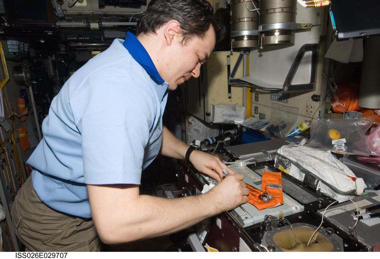 ISS026-E-029707 (25 Feb. 2011) --- Russian cosmonaut Oleg Skripochka, Expedition 26 flight engineer, labels surface sampling tubes in the Zvezda Service Module of the International Space Station.