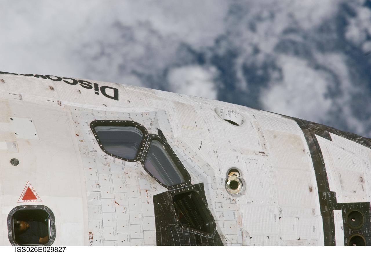 ISS026-E-029827 (26 Feb. 2011) --- This close-up view of the port side of the crew cabin of space shuttle Discovery was provided by an Expedition 26 crew member during a survey of the approaching STS-133 vehicle prior to docking with the International Space Station. As part of the survey and part of every mission's activities, Discovery performed a back-flip for the rendezvous pitch maneuver (RPM). The station crew member used a digital still camera with an 800mm focal length, as the two spacecraft were approximately 600 feet (180 meters) apart.