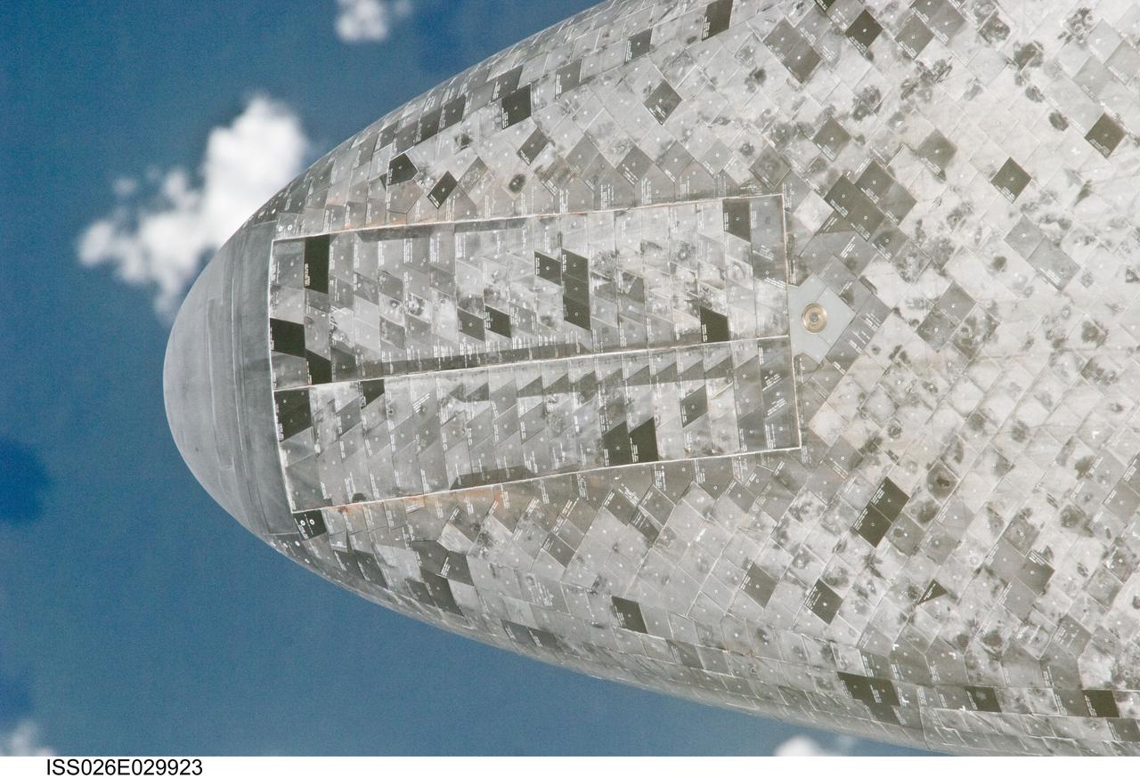 ISS026-E-029923 (26 Feb. 2011) --- This underside view of the nose of the space shuttle Discovery was provided by an Expedition 26 crew member during a survey of the approaching STS-133 vehicle prior to docking with the International Space Station. As part of the survey and part of every mission's activities, Discovery performed a back-flip for the rendezvous pitch maneuver (RPM). The station crew member used a digital still camera with an 800mm focal length, as the two spacecraft were approximately 600 feet (180 meters) apart.