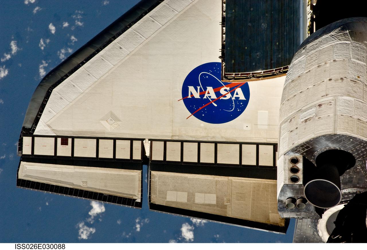 ISS026-E-030088 (26 Feb. 2011) --- This partial view of the port wing of the space shuttle Discovery was provided by an Expedition 26 crew member during a survey of the approaching STS-133 vehicle prior to docking with the International Space Station. As part of the survey and part of every mission's activities, Discovery performed a back-flip for the rendezvous pitch maneuver (RPM). The image was photographed with a digital still camera, using a 400mm lens at a distance of about 600 feet (180 meters).