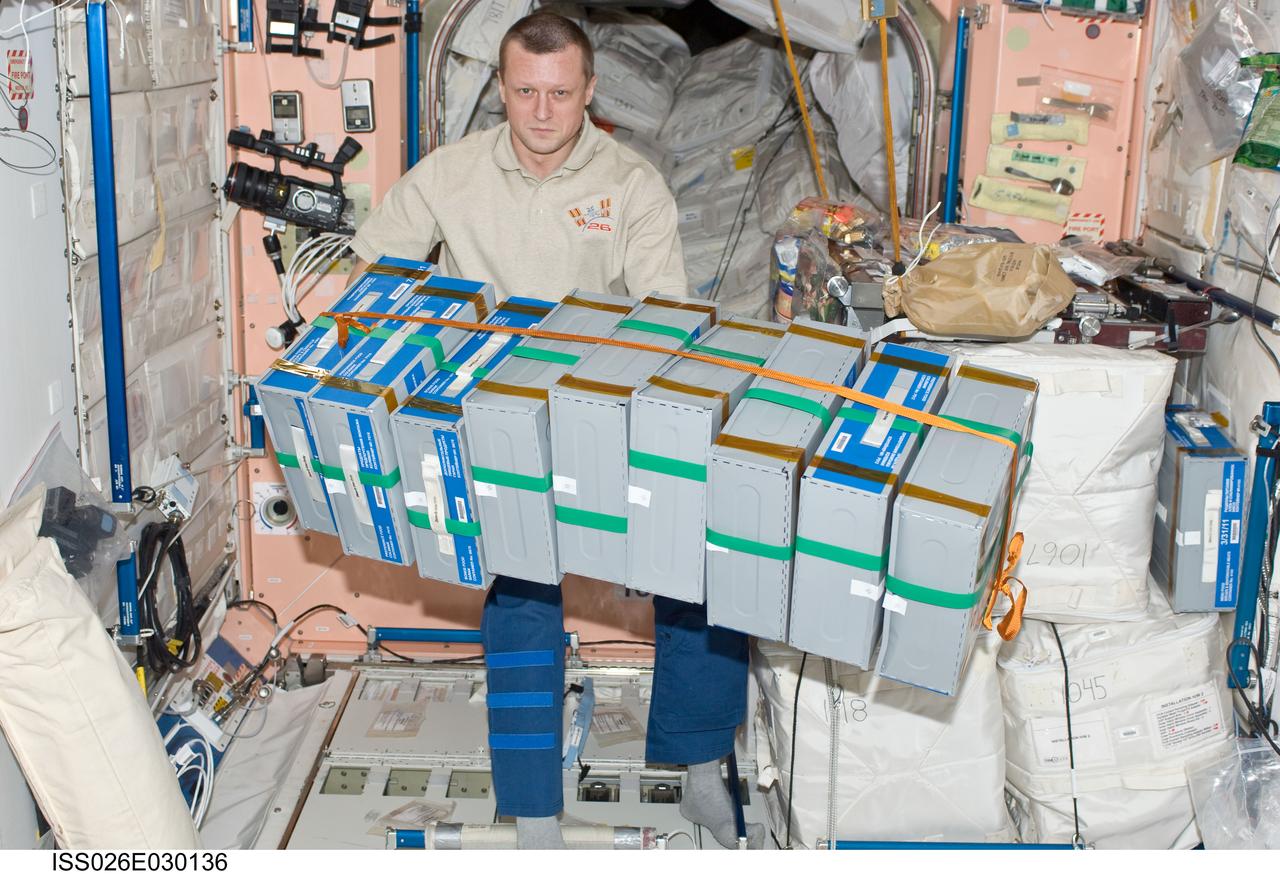 ISS026-E-030136 (25 Feb. 2011) --- Russian cosmonaut Dmitry Kondratyev, Expedition 26 flight engineer, moves stowage containers in the Unity node of the International Space Station.