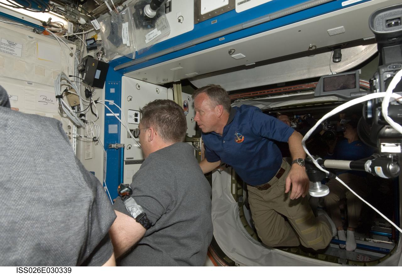 ISS026-E-030339 (26 Feb. 2011) --- NASA astronauts Steve Lindsey (right), STS-133 commander; and Steve Bowen, mission specialist, are pictured shortly after space shuttle Discovery and the International Space Station docked in space and the hatches were opened.