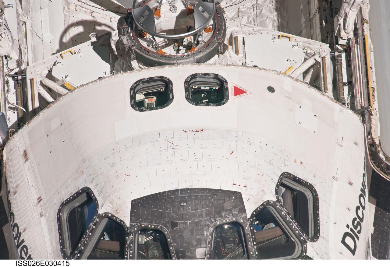 ISS026-E-030415 (26 Feb. 2011) --- This high angle, partial view of the crew cabin of the space shuttle Discovery was provided by an Expedition 26 crew member during a survey of the approaching STS-133 vehicle prior to docking with the International Space Station. As part of the survey and part of every mission's activities, Discovery performed a back-flip for the rendezvous pitch maneuver (RPM). The image was photographed with a digital still camera, using a 1000mm lens.