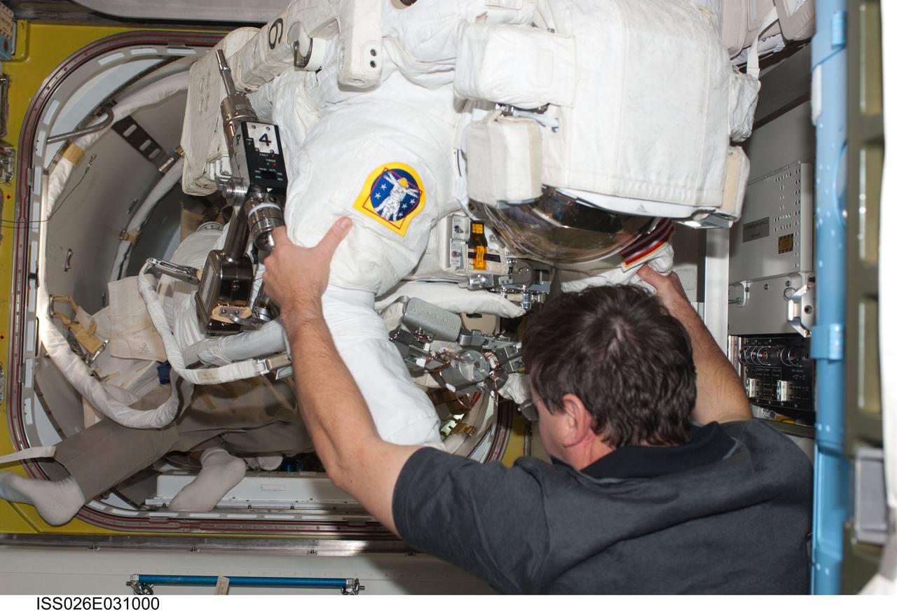 ISS026-E-031000 (28 Feb. 2011) ---  Attired in his Extravehicular Mobility Unit (EMU) spacesuit, NASA astronaut Alvin Drew, STS-133 mission specialist, enters the International Space Station?s Quest airlock as the mission?s first spacewalk draws to a close. NASA astronaut Michael Barratt, mission specialist, assisted Drew. Photo credit: NASA or National Aeronautics and Space Administration