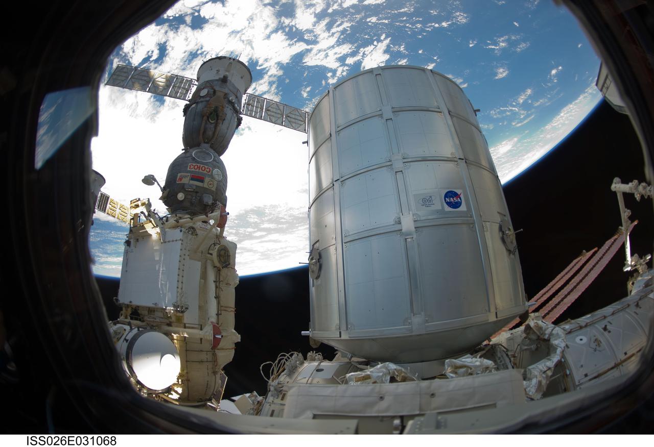 ISS026-E-031068 (1 March 2011) --- The newly-attached Permanent Multipurpose Module (PMM) and a docked Russian Soyuz spacecraft are featured in this image photographed by an Expedition 26 crew member while space shuttle Discovery (STS-133) remains docked with the station. Earth?s horizon and the blackness of space provide the backdrop for the scene.