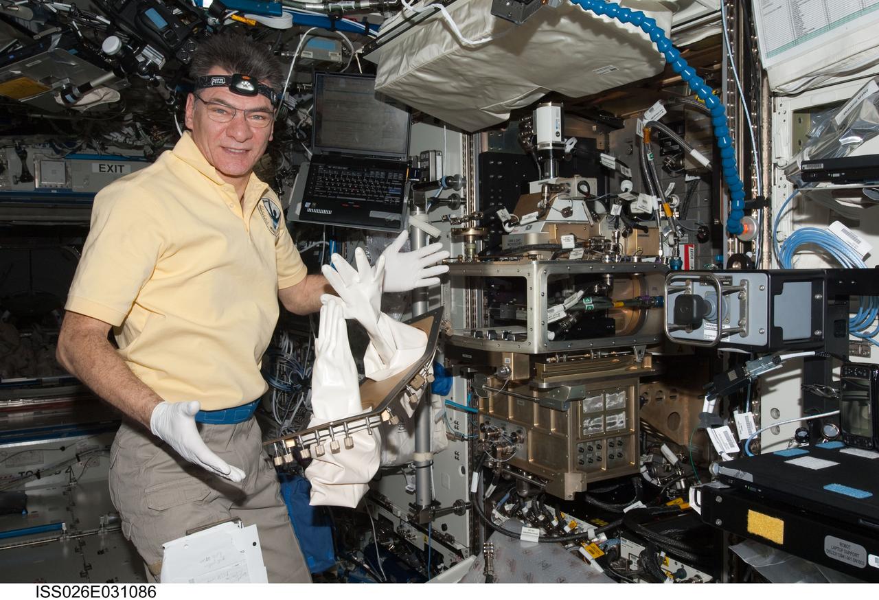 ISS026-E-031086 (1 March 2011) --- European Space Agency astronaut Paolo Nespoli, Expedition 26 flight engineer, works with the Light Microscopy Module (LMM) Spindle Bracket Assembly in the Fluids Integrated Rack (FIR) in the Destiny laboratory of the International Space Station.