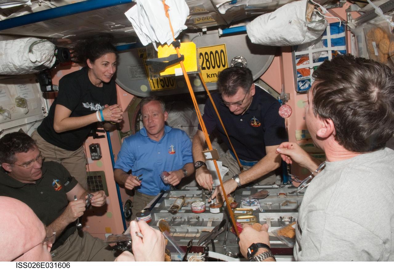 ISS026-E-031606 (3 March 2011) --- Expedition 26 and STS-133 crew members share a meal in the Unity node of the International Space Station while space shuttle Discovery remains docked with the station. Pictured from the left are NASA astronauts Steve Bowen, Nicole Stott, both STS-133 mission specialists; Steve Lindsey, STS-133 commander; European Space Agency astronaut Paolo Nespoli, Expedition 26 flight engineer; and NASA astronaut Michael Barratt, STS-133 mission specialist.