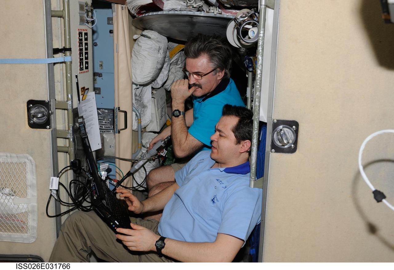 ISS026-E-031766 (4 March 2011) --- Russian cosmonauts Oleg Skripochka (foreground) and Alexander Kaleri, both Expedition 26 flight engineers, watch a computer monitor in the Zvezda Service Module of the International Space Station.