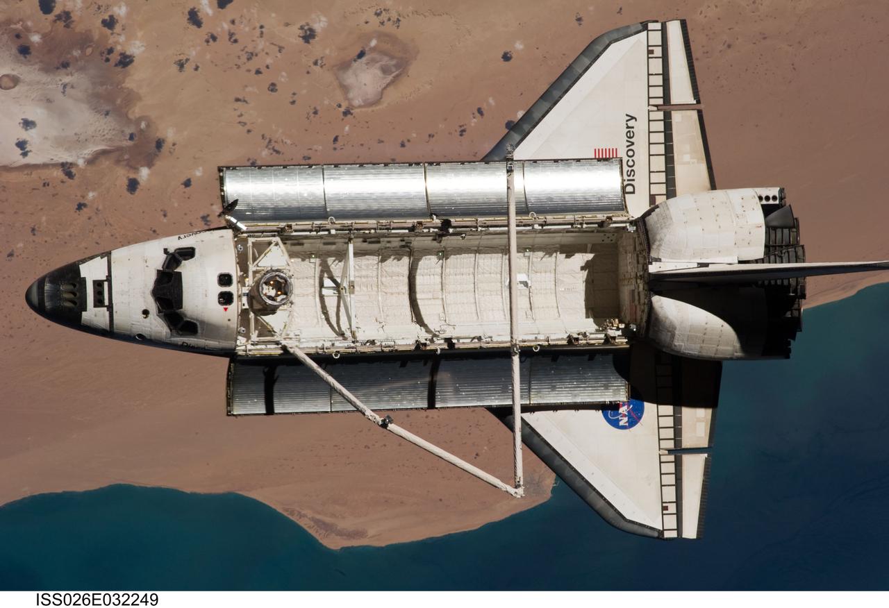 ISS026-E-032249 (7 March 2011) --- The space shuttle Discovery is seen from the International Space Station as the two orbital spacecraft accomplish their relative separation on March 7 after an aggregate of 12 astronauts and cosmonauts worked together for over a week. The area below is the southwestern coast of Morocco in the northern Atlantic. During a post undocking fly-around, the crew members aboard the two spacecraft collected a series of photos of each other’s vehicle.