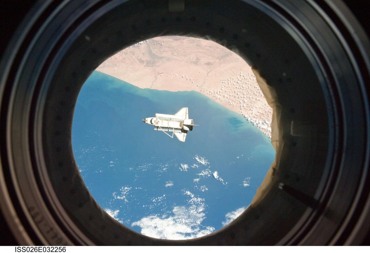 ISS026-E-032256 (7 March 2011) --- The space shuttle Discovery is seen from the International Space Station as the two orbital spacecraft accomplish their relative separation on March 7 after an aggregate of 12 astronauts and cosmonauts worked together for over a week. The area below is the southwestern coast of Morocco in the northern Atlantic. During a post undocking fly-around, the crew members aboard the two spacecraft collected a series of photos of each other’s vehicle.