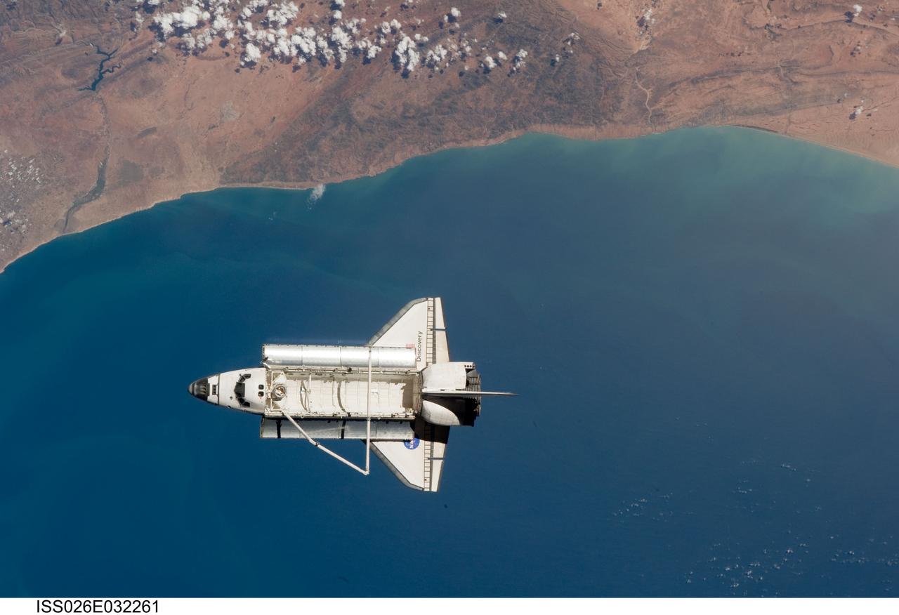 ISS026-E-032261 (7 March 2011) --- The space shuttle Discovery is seen from the International Space Station as the two orbital spacecraft accomplish their relative separation on March 7 after an aggregate of 12 astronauts and cosmonauts worked together for over a week. The area below is the southwestern coast of Morocco in the northern Atlantic. During a post undocking fly-around, the crew members aboard the two spacecraft collected a series of photos of each other’s vehicle.