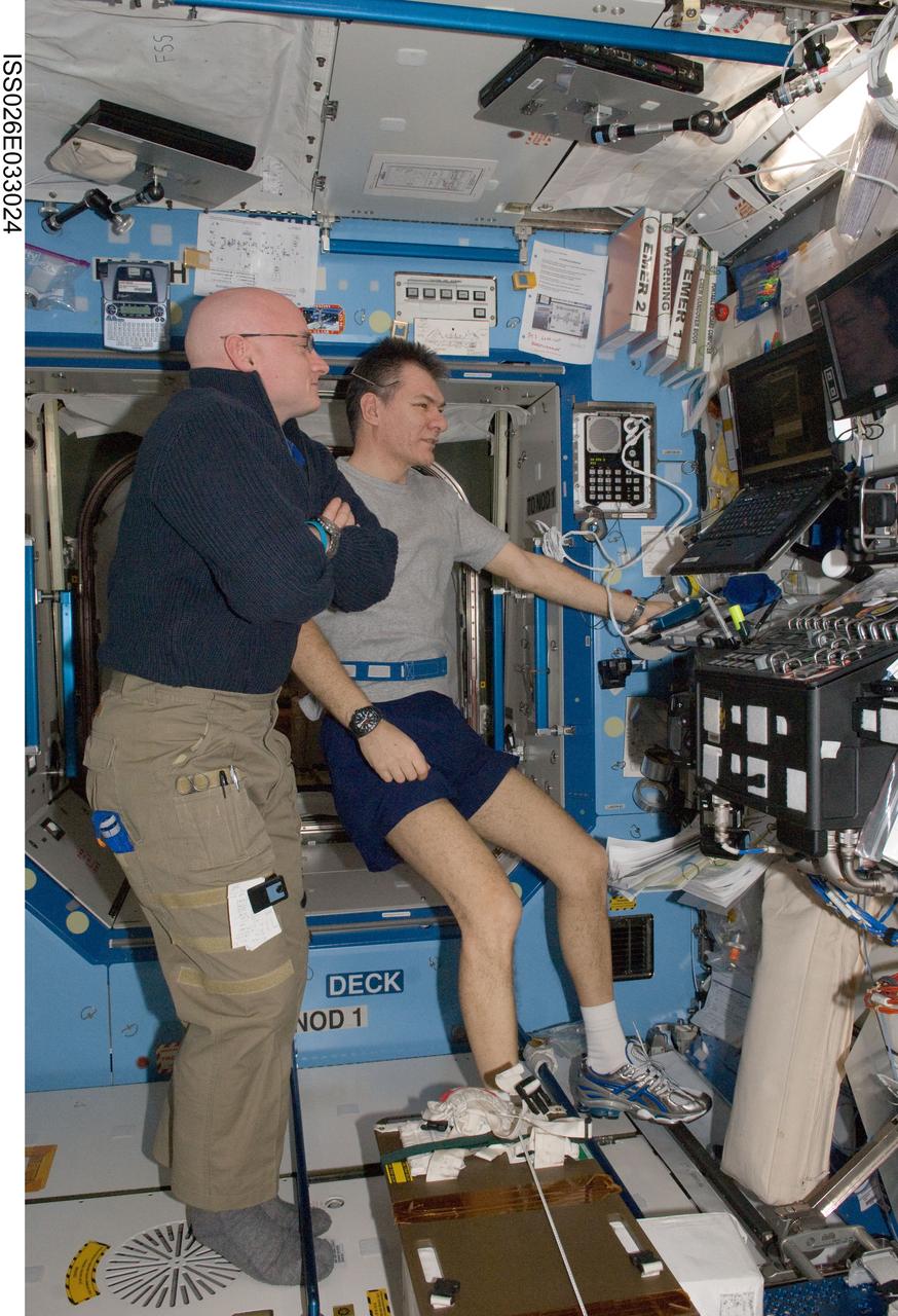 ISS026-E-033024 (9 March 2011) --- NASA astronaut Scott Kelly (foreground), Expedition 26 commander; and European Space Agency astronaut Paolo Nespoli, flight engineer, watch the landing of space shuttle Discovery (STS-133) on a computer monitor in the Destiny laboratory of the International Space Station.
