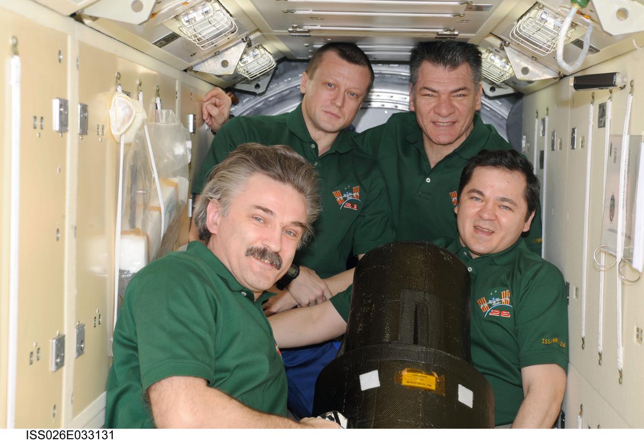 ISS026-E-033131 (11 March 2011) --- Russian cosmonauts Alexander Kaleri (left foreground), Oleg Skripochka (right foreground), Dmitry Kondratyev (left background) and European Space Agency astronaut Paolo Nespoli, all Expedition 26 flight engineers, pose for a photo with the European Matroshka-R Phantom experiment in the Zarya Functional Cargo Block (FGB) of the International Space Station. Matroshka, the name for the traditional Russian set of nestling dolls, is an antroph-amorphous model of a human torso designed for radiation studies.