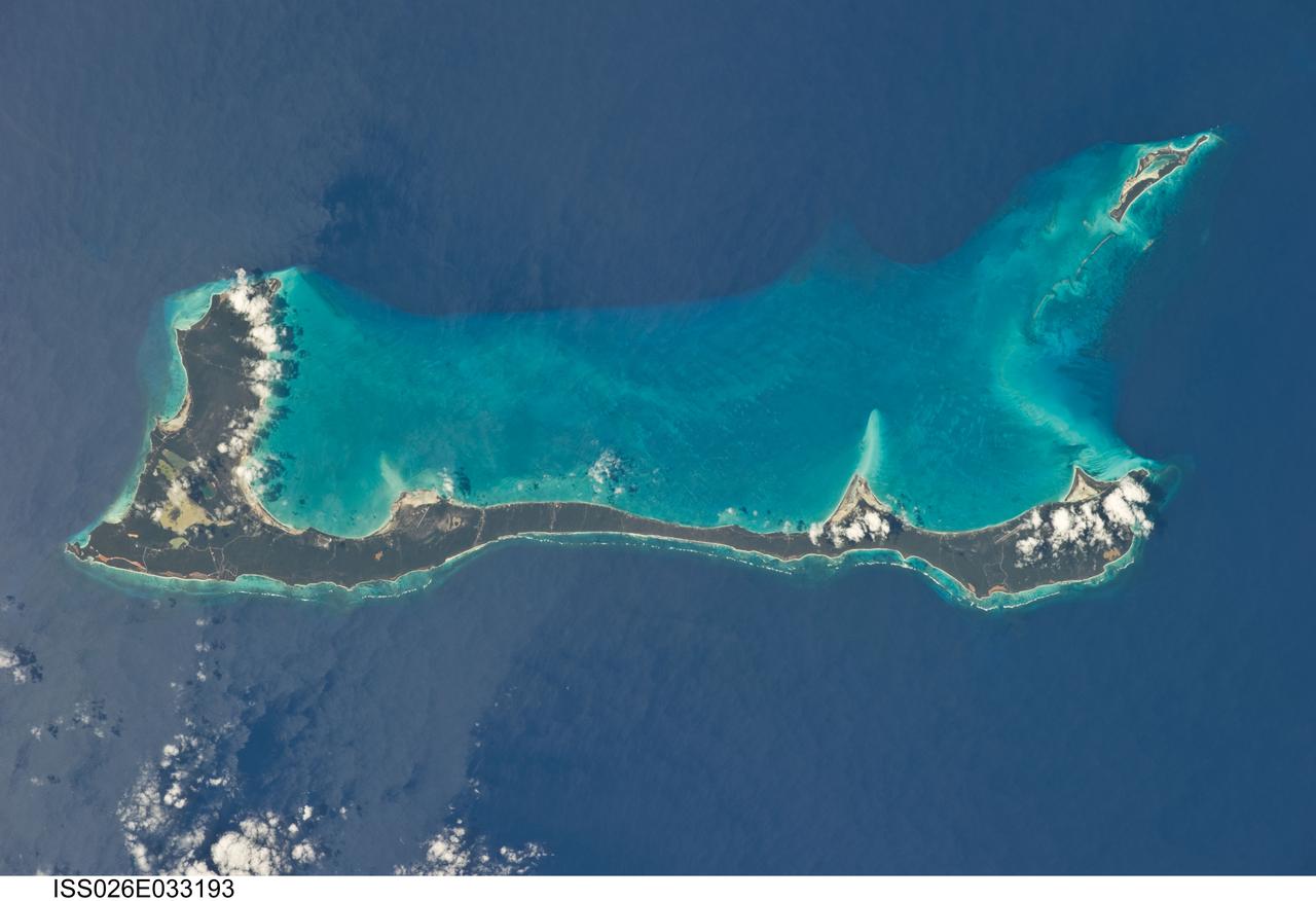 ISS026-E-033193 (10 March 2011) --- Cat Island, Commonwealth of the Bahamas, is featured in this image photographed by an Expedition 26 crew member on the International Space Station. Cat Island is one of 29 islands, 661 cays, and 2,387 islets that form the Commonwealth of the Bahamas. Mount Alvernia, the highest point in the Bahamas at an elevation of approximately 63 meters above sea level, is located on the southeastern part of the island. Like most other islands in the Bahamas, Cat Island is located on a large depositional platform that is composed mainly of carbonate sediments and surrounding reefs. The approximately 77-kilometers-long island is the part of the platform continuously exposed above the water surface; this allows for soil development (brown to tan areas) and establishment of vegetation (green areas) to occur. Shallow water to the west-southwest of the island appears bright blue in this photograph (center) in contrast to the deeper ocean waters to the north, east, and south. The ocean surface near the southeastern half of the island has a slight grey tinge; this is due to sunglint, or light reflecting off of the water surface backs towards the observer onboard the space station. Small white cumulus clouds obscure some parts of the island. Named San Salvador prior to 1925, the island has been put forward as a candidate for Christopher Columbus’ first landfall in the Americas. Cat Island is inhabited, and had a total population of 1,647 in 2000 according to the Department of Statistics of the Bahamas. The smaller island of Little San Salvador to the west is privately owned and used as a port of call for cruise ships.