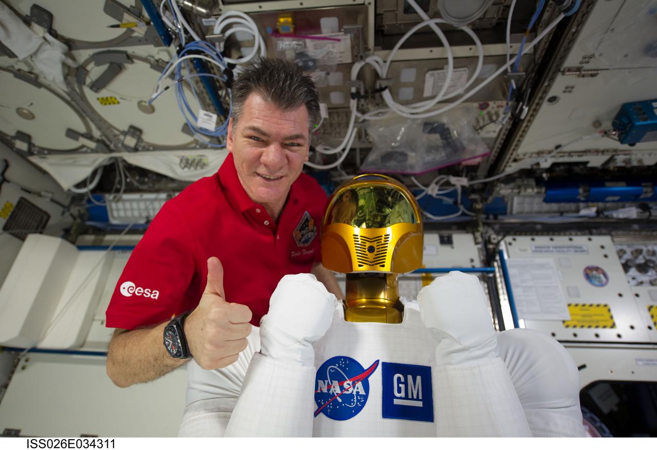 ISS026-E-034311 (15 March 2011) --- European Space Agency astronaut Paolo Nespoli, Expedition 26/27 flight engineer, poses with Robonaut 2, the dexterous humanoid astronaut helper, in the Destiny laboratory of the International Space Station.