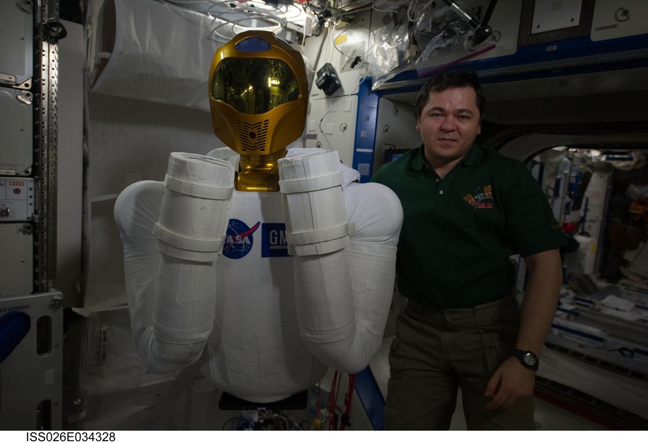 ISS026-E-034328 (15 March 2011) --- Russian cosmonaut Oleg Skripochka, Expedition 26 flight engineer, poses with Robonaut 2, the dexterous humanoid astronaut helper, in the Destiny laboratory of the International Space Station.