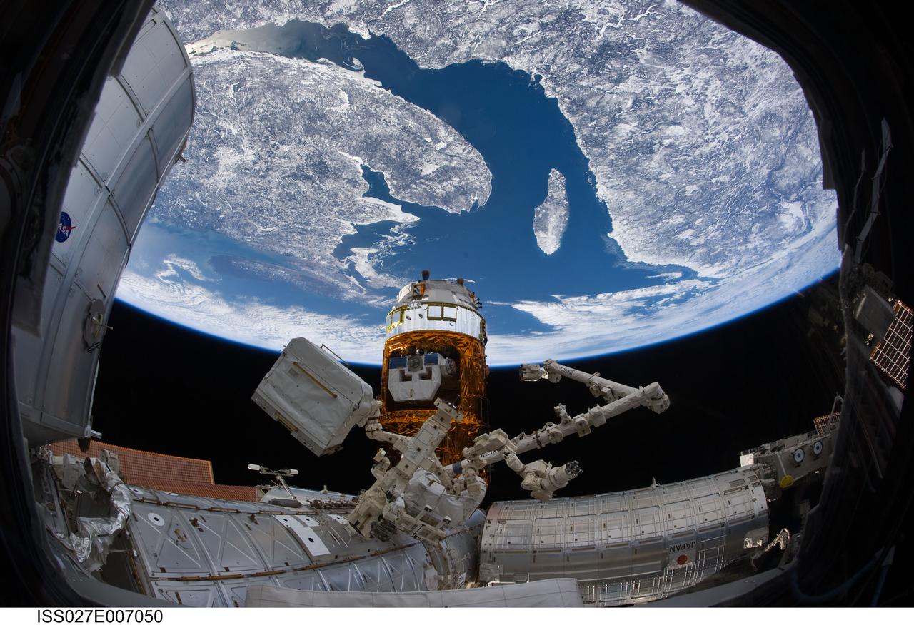 ISS027-E-007050 (20 March 2011) --- The docked Kounotori2 H-II Transfer Vehicle (HTV-2) and part of the International Space Station’s remote manipulator robot system known as Dextre, also known as the Special Purpose Dextrous Manipulator (SPDM), are pictured as photographed by an Expedition 27 crew member, using a camera equipped with a fish-eye lens,  aboard the International Space Station. The scene on Earth, some 220 miles below, includes the Gulf of St. Lawrence leading to the St. Lawrence Seaway. North is toward the upper right corner. The large Island near the center is Anticosti Island. Nova Scotia, Bay of Fundy, New Brunswick and northern Maine are seen to the left side of the image and Quebec and Newfoundland and Labrador are shown on the right of the image.