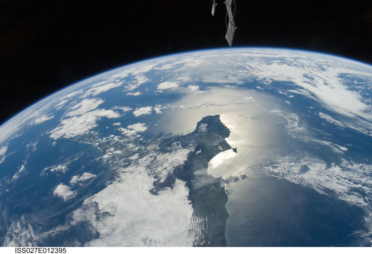 ISS027-E-012395 (13 April 2011)--– One of the Expedition 27 crew members aboard the International Space Station photographed this southeastward looking panoramic view centered on the Azuero Peninsula of Panama. The southwestern Caribbean Sea and the cloud-covered Isthmus of Panama are to the left and the Gulf of Panama and the eastern Pacific Ocean with sun glint are on the right.