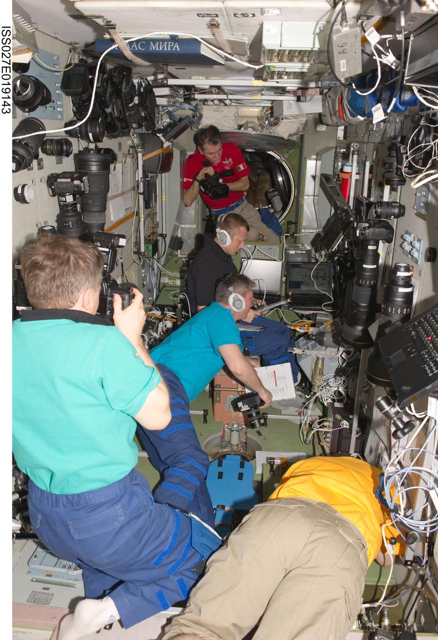 ISS027-E-019143 (29 April 2011) --- Expedition 27 crew members are busy at work in the Zvezda Service Module of the International Space Station during rendezvous and docking activities of the ISS Progress 42 supply vehicle. Pictured are Russian cosmonauts Andrey Borisenko (left foreground), Alexander Samokutyaev (center foreground) and Dmitry Kondratyev; along with European Space Agency astronaut Paolo Nespoli (background) and NASA astronaut Ron Garan (right foreground).