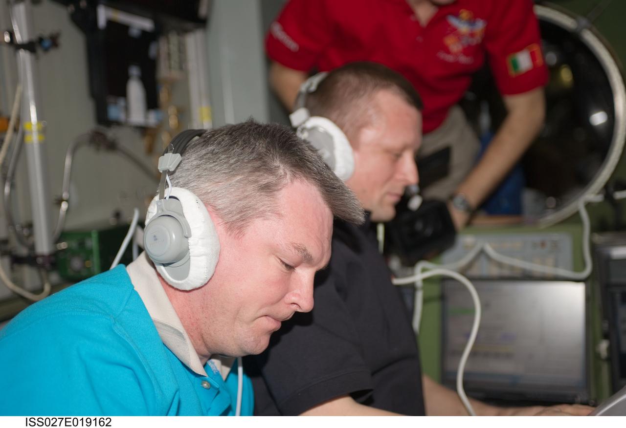 ISS027-E-019162 (29 April 2011) --- Russian cosmonauts Alexander Samokutyaev (foreground), Expedition 27 flight engineer; and Dmitry Kondratyev, commander, are busy at work in the Zvezda Service Module of the International Space Station during rendezvous and docking activities of the ISS Progress 42 supply vehicle.