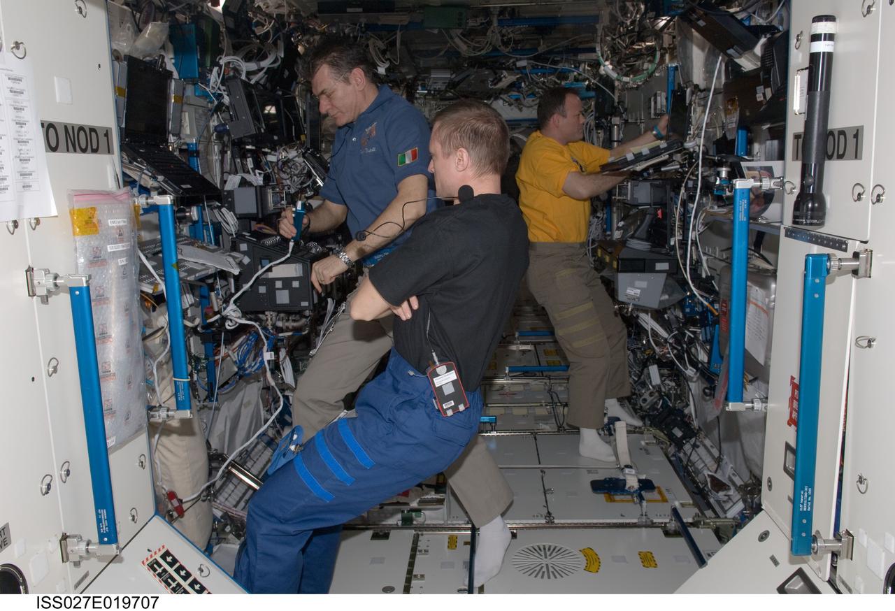 ISS027-E-019707 (25 April 2011) --- Russian cosmonaut Dmitry Kondratyev (foreground), Expedition 27 commander; along with European Space Agency astronaut Paolo Nespoli and NASA astronaut Ron Garan (right background), both flight engineers, work in the Destiny laboratory of the International Space Station.