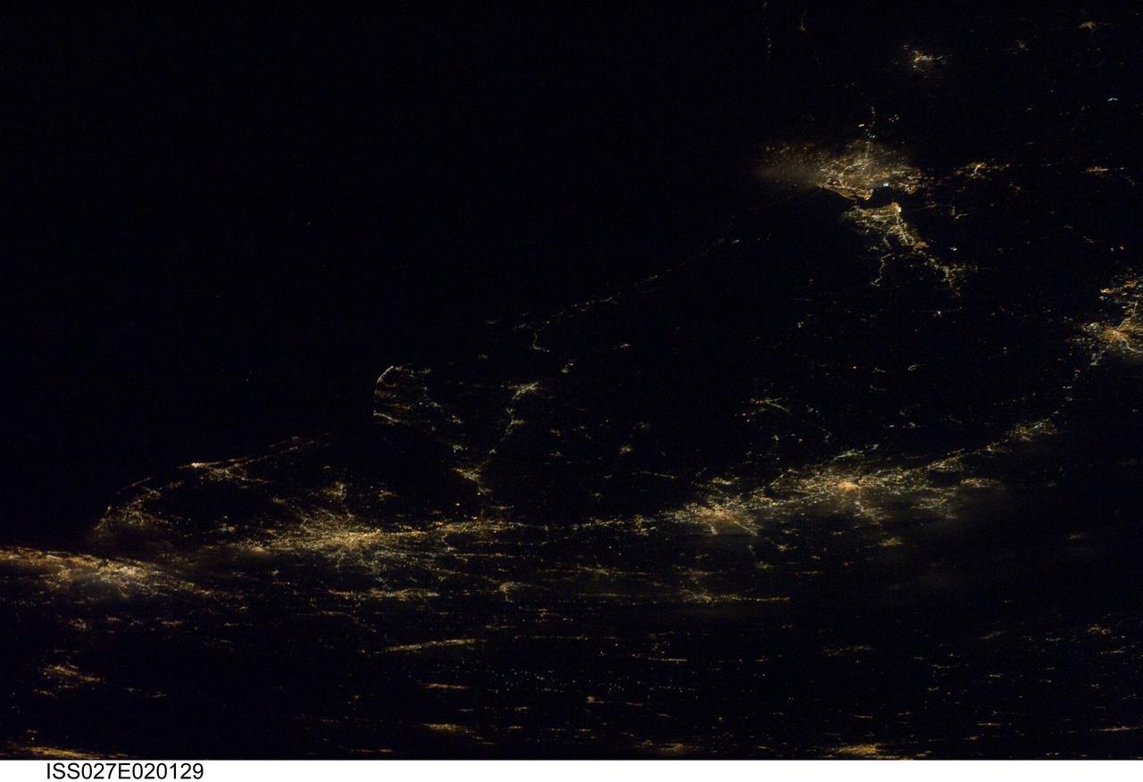 ISS027-E-020129 (6 April 2011) --- A night time view of the Atlantic Seaboard Conurbation, United States of America, is featured in this image photographed by an Expedition 27 crew member on the International Space Station. As regional metropolitan areas expand in both physical area and population, they typically aggregate to form economically, politically, and to some extent socially linked entities known as conurbations – the term “megalopolis” has also been used. One of the largest conurbations in the world is located along the eastern coastline of the United States, and has been termed the Atlantic Seaboard Conurbation (ASC). The ASC extends over 1,000 kilometers and includes the major economic, governmental, and cultural centers of Boston, Mass.; New York, N.Y.; Philadelphia, Pa.; Baltimore, Md.; and Washington, D.C. This photograph includes every metropolitan area in the ASC except for Boston, Mass. (located off the image to the northeast of New York, N.Y.). The image was taken during “local night”, which highlights the position and extent of each metropolitan area along the eastern seaboard by their urban lighting patterns. The establishment and growth of the conurbation was facilitated by transportation networks (railroads, highways, and air travel routes) for transfer of goods, materials, and population between the metropolitan areas. Two other large metropolitan areas are visible in the image – Norfolk, Va. and Richmond, Va. at upper right – but these are not considered to be part of the ASC. In contrast to the city lights that mark metropolitan areas and smaller communities along the sea coast and interior, the Atlantic Ocean appears as a featureless dark region occupying the upper left quarter of the image.