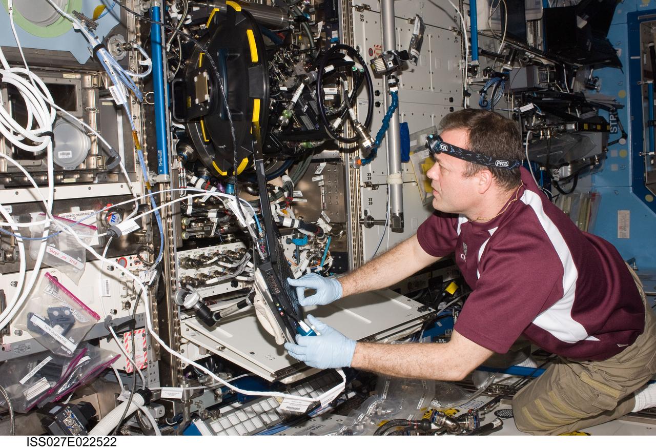 ISS027-E-022522 (5 May 2011) --- NASA astronaut Ron Garan, Expedition 27 flight engineer, services the Combustion Integrated Rack (CIR) Multi-user Drop Combustion Apparatus (MDCA) in the Destiny laboratory of the International Space Station.