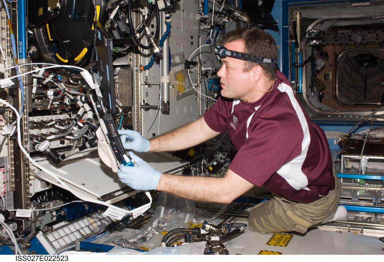 ISS027-E-022523 (5 May 2011) --- NASA astronaut Ron Garan, Expedition 27 flight engineer, services the Combustion Integrated Rack (CIR) Multi-user Drop Combustion Apparatus (MDCA) in the Destiny laboratory of the International Space Station.