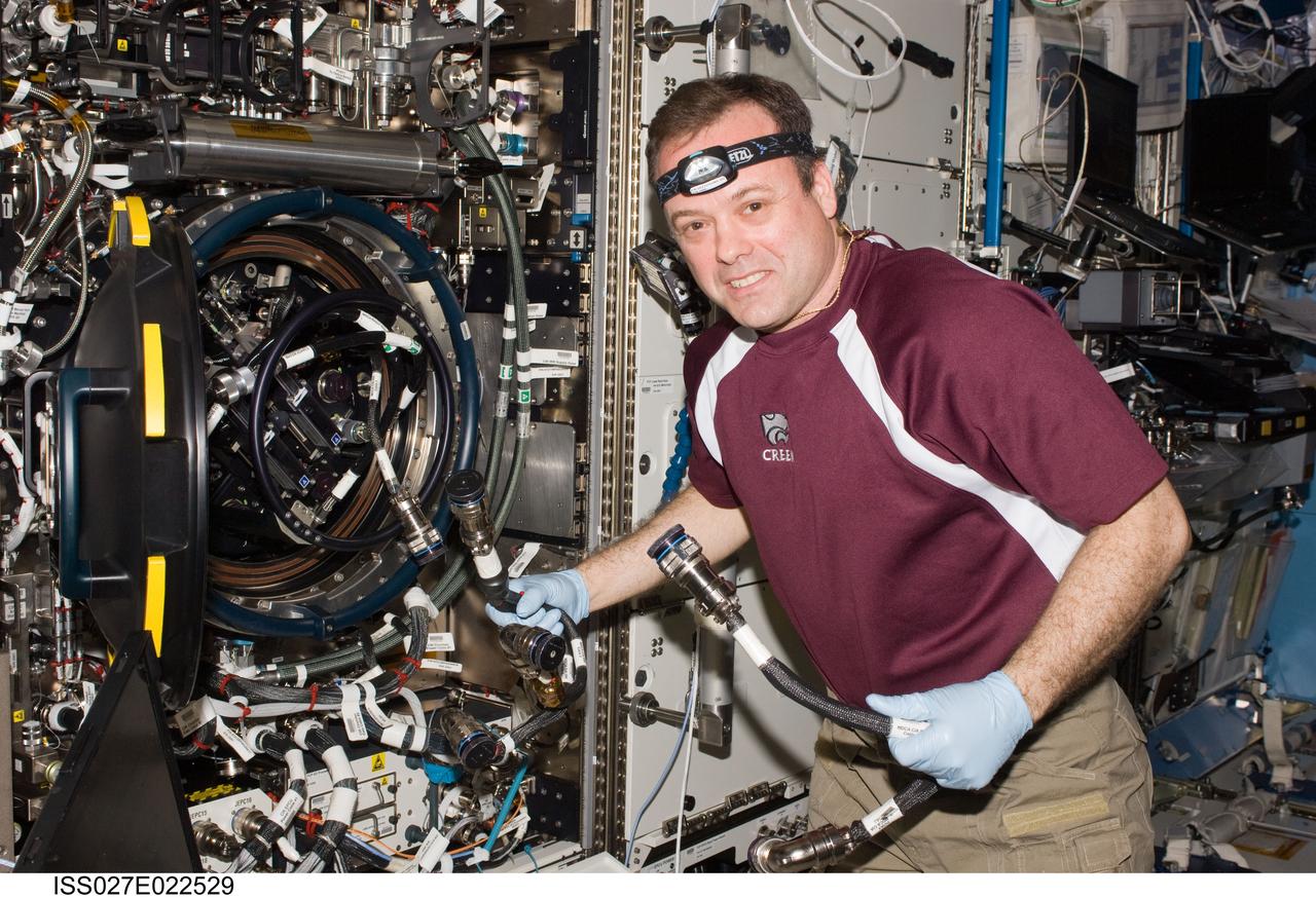 ISS027-E-022529 (5 May 2011) --- NASA astronaut Ron Garan, Expedition 27 flight engineer, services the Combustion Integrated Rack (CIR) Multi-user Drop Combustion Apparatus (MDCA) in the Destiny laboratory of the International Space Station.