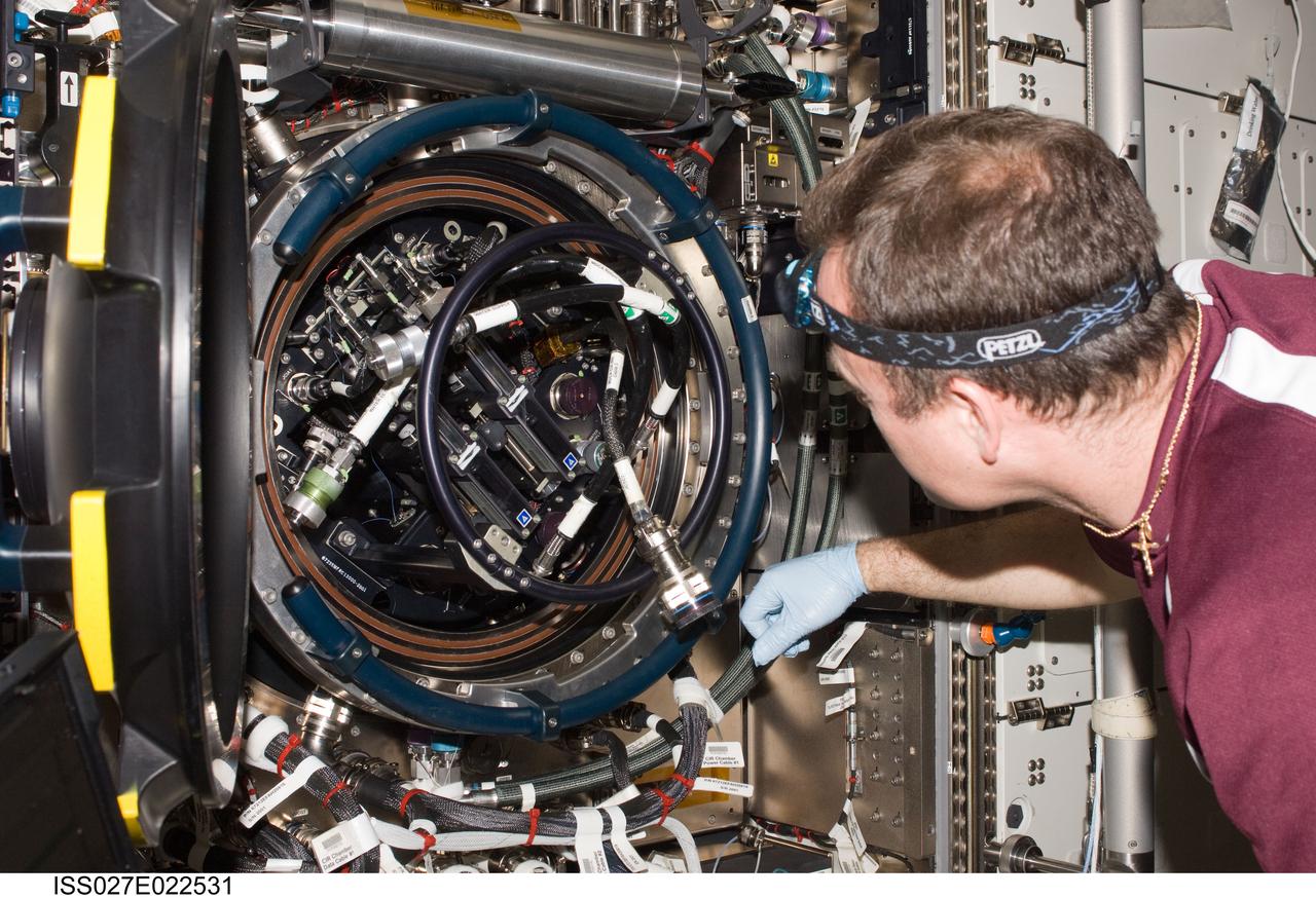 ISS027-E-022531 (5 May 2011) --- NASA astronaut Ron Garan, Expedition 27 flight engineer, services the Combustion Integrated Rack (CIR) Multi-user Drop Combustion Apparatus (MDCA) in the Destiny laboratory of the International Space Station.