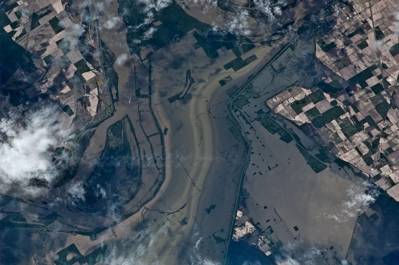 ISS027-E-027026 (12 May 2011) --- An Expedition 27 crew member recorded this image aboard the International Space Station as the orbital outpost was passing over the Mississippi River flood waters from 220 miles above.  North is toward the bottom of the image, which was captured using a 400-mm lens.  This highly impacted area, centered near 36.6 degrees north latitude and 89.5 degrees west longitude, is just east of New Madrid, Mo. (visible in upper right). Levees appear to be intact here, but there is extensive lowland crop flooding.