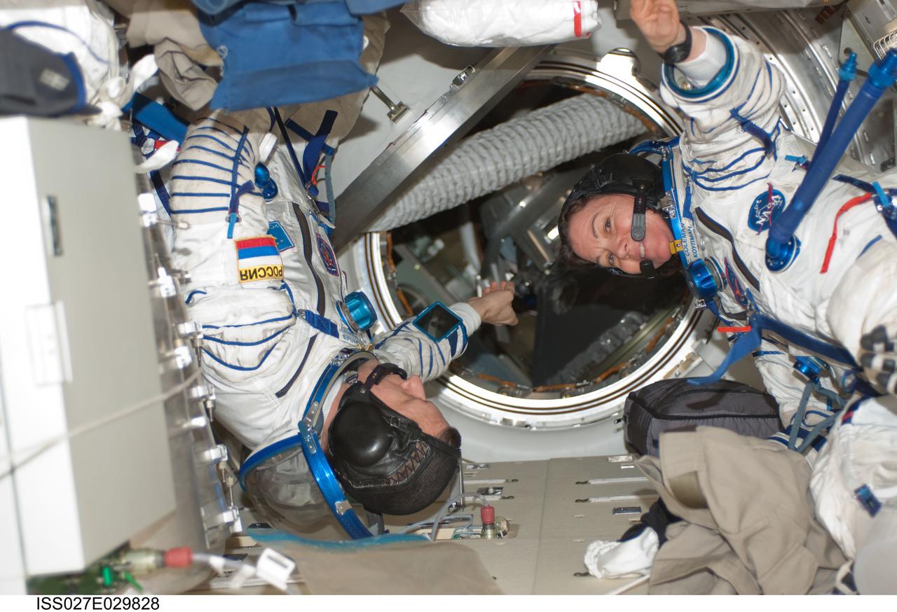 ISS027-E-029828 (13 May 2011) --- Attired in their Russian Sokol launch and entry suits, Russian cosmonaut Dmitry Kondratyev, Expedition 27 commander; and NASA astronaut Cady Coleman, flight engineer, prepare to perform a fit check in their body-contoured Kazbek couches in the Soyuz TMA-20 spacecraft docked to the International Space Station. Kondratyev, Coleman and European Space Agency astronaut Paolo Nespoli (out of frame) are scheduled to return to Earth on May 23.