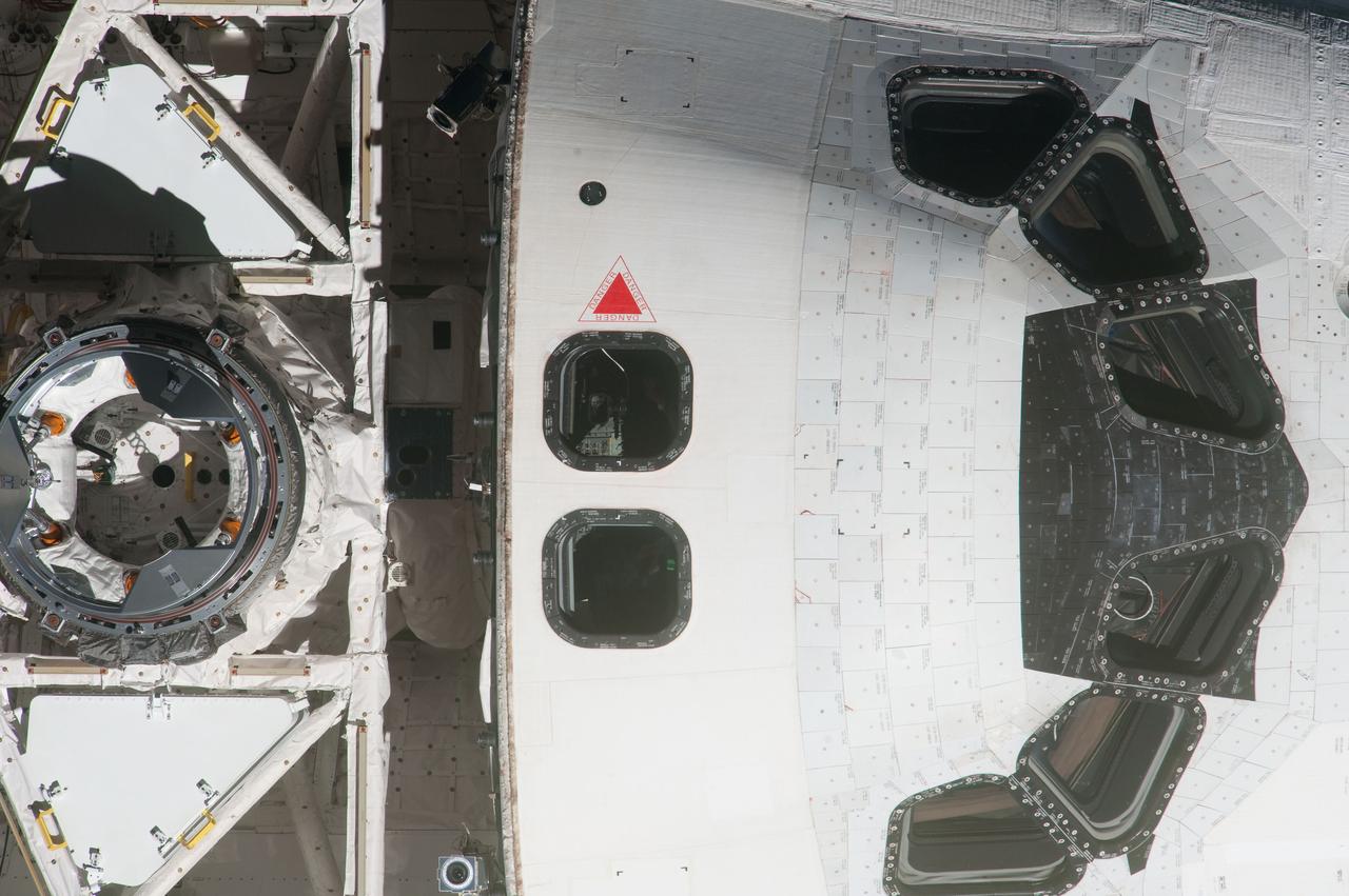 ISS027-E-032405 (18 May 2011) --- This high angle, partial view of the space shuttle Endeavour’s crew cabin and docking mechanism was provided by an Expedition 27 crew member during a survey of the approaching STS-134 vehicle prior to docking with the International Space Station. As part of the survey and part of every mission's activities, Endeavour performed a back-flip for the rendezvous pitch maneuver (RPM). The image was photographed with a digital still camera, using a 1000mm lens.