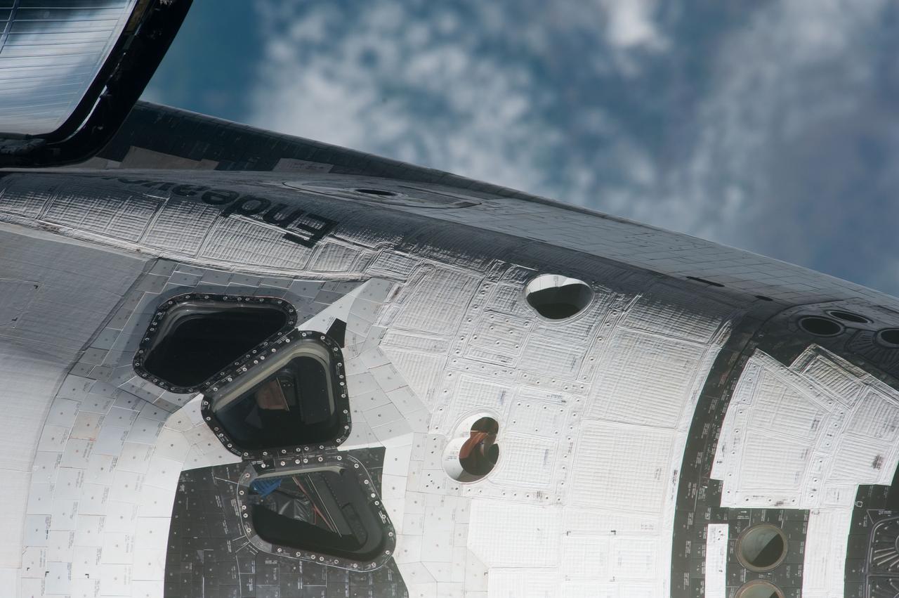 ISS027-E-032428 (18 May 2011) --- This high angle, partial view of the port side of the space shuttle Endeavour’s crew cabin was provided by an Expedition 27 crew member during a survey of the approaching STS-134 vehicle prior to docking with the International Space Station. As part of the survey and part of every mission's activities, Endeavour performed a back-flip for the rendezvous pitch maneuver (RPM). The image was photographed with a digital still camera, using a 1000mm lens.