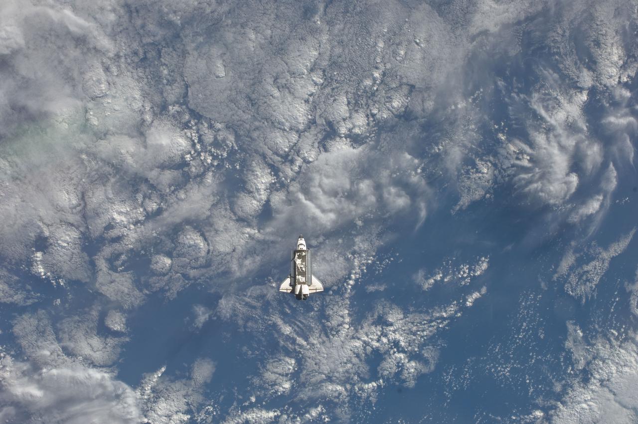 ISS027-E-032606 (18 May 2011) --- One of the Expedition 27 crew members aboard the International Space Station (ISS) recorded this image of the distant space shuttle Endeavour, appearing somewhat incidentally camouflaged by the white clouds, as the two spacecraft made their relative approach on May 18, 2011. Each spacecraft was occupied by six crew members until the STS-134 astronauts entered the ISS minutes after the docking.