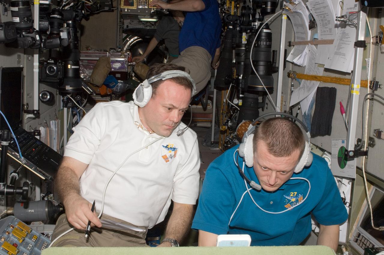 ISS027-E-032650 (18 May 2011) --- Onboard the International Space Station (ISS), Russian cosmonaut Dmitry Kondratyev(right), Expedition 27 commander,and NASA astronaut Ron Garan, flight engineer, support the May 18, 2011 docking of space shuttle Endeavour and the ISS.