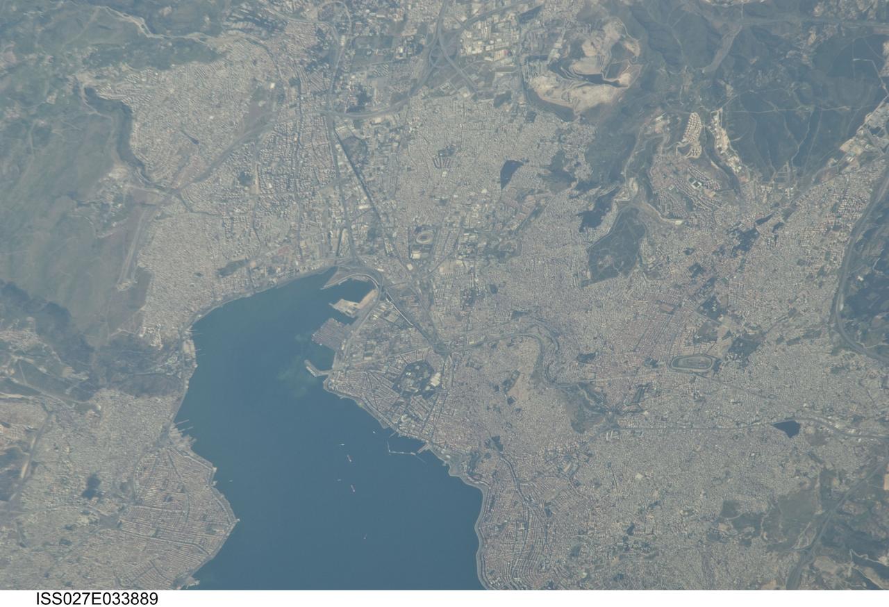 ISS027-E-033889 (16 May 2011) --- Izmir Metropolitan Area, Izmir Province in Turkey is featured in this image photographed by an Expedition 27 crew member on the International Space Station. The metropolis of Izmir is located in the western Anatolia region of Turkey. It is the country’s third largest city in terms of population and the second largest port city (after Istanbul). The Izmir region has included urban areas for almost 3,500 years, and the ancient core of the metropolitan area was originally known as Smyrna. Due to its location on the Gulf of Izmir (lower left) with access to the Aegean Sea, Izmir (or Smyrna) has been an important Mediterranean Sea port for most of its history. This detailed photograph highlights the modern urban landscape of the Izmir metropolitan area. Today, the metropolitan area includes eleven districts, many of which were independent neighborhoods prior to agglomeration into “greater Izmir”. Densely built-up residential and commercial districts, characterized by gray to reddish gray rooftops occupy much of the central part of the image. Larger structures with bright white rooftops are indicative of commercial/industrial areas near the Izmir Port at left. Two large sport complexes, the Ataturk Stadium and Sirinyer Hippodrome (horse racing track) are clearly visible at upper left and right respectively. Numerous vegetated parks (green) are located throughout the area. In addition to being a major trade center, greater Izmir is a hub for regional tourism.