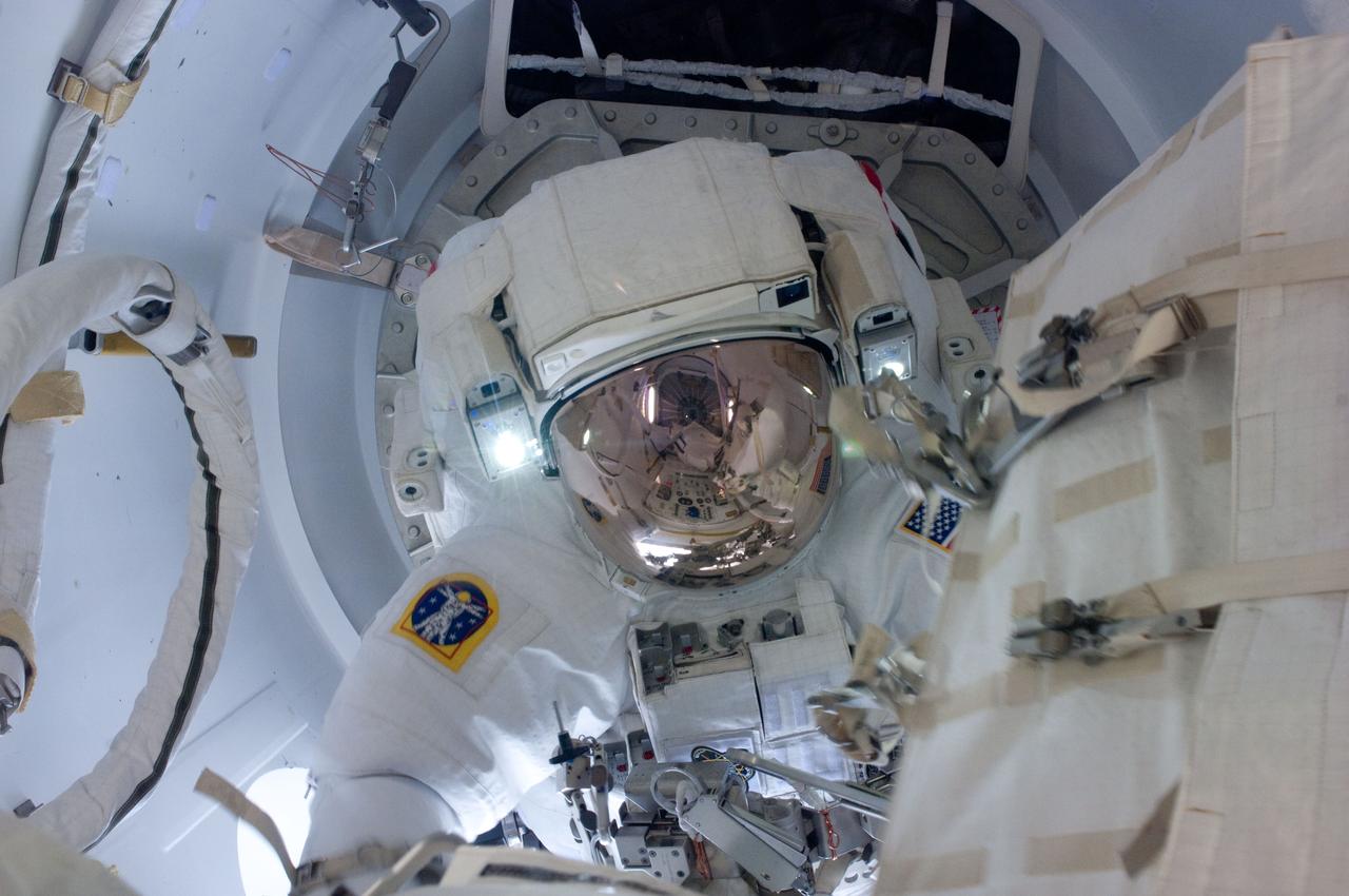 ISS027-E-034395 (20 May 2011) --- Attired in his Extravehicular Mobility Unit (EMU) spacesuit, NASA astronaut Greg Chamitoff, STS-134 mission specialist, exits the International Space Station?s Quest airlock to begin the first session of extravehicular activity (EVA) for the STS-134 mission. Astronaut Andrew Feustel (out of frame), mission specialist, joined Chamitoff on the spacewalk.