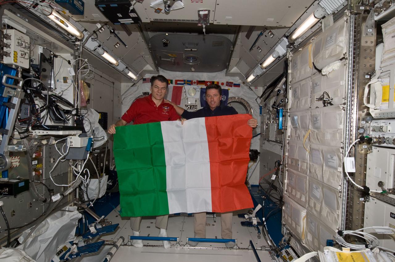 ISS027-E-036175 (23 May 2011) --- Inside the Japan Aerospace Exploration  Agency's Kibo lab on the International Space Station (ISS), European Space Agency astronauts Paolo Nespoli (left) and Roberto Vittori display the Italian flag during an Earth-to-space phone tag-up with  Italian President Giorgio Napolitano. Nespoli has been on the station for over five months and is due to return to Earth in less than 24 hours. Vittori is on a 16-day mission of the space shuttle Endeavour,  joined by five NASA astronauts. This occasion is the second time two Italian astronauts have been in space together and the first time in the last 15 years.