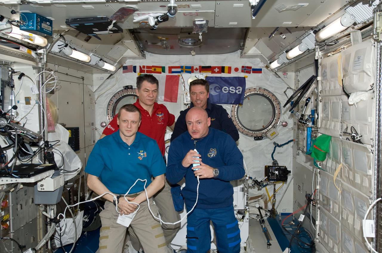 ISS027-E-036218 (23 May 2011) --- Inside the Japan Aerospace Exploration Agency's Kibo lab on the International Space Station (ISS), European Space Agency astronauts Paolo Nespoli (left rear) and Roberto Vittori (right rear) are pictured during an Earth-to-space phone tag-up with Italian President Giorgio Napolitano. Russian cosmonaut Dmitry Kondratyev (left front) and Mark Kelly, the respective commanders for the two, introduced the ESA astronauts and left them in Kibo to visit with the president. Nespoli has been on the station for over five months and is due to return to Earth in less than 24 hours. Vittori is on a 16-day mission of the space shuttle Endeavour, joined by five NASA astronauts. This occasion is the second time two Italian astronauts have been in space together and the first time in the last 15 years.