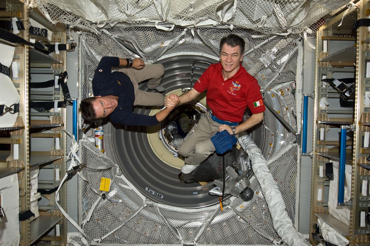 ISS027-E-036248 (23 May 2011) --- Onboard the International Space Station, European Space Agency astronauts Paolo Nespoli (left) and Roberto Vittori shake hands following an Earth-to-space phone tag-up with Italian President Giorgio Napolitano. Nespoli has been on the station for over five months and is due to return to Earth in less than 24 hours. Vittori is on a 16-day mission of the space shuttle Endeavour,  joined by five NASA astronauts. This occasion is the second time two Italian astronauts have been in space together and the first time in the last 15 years.