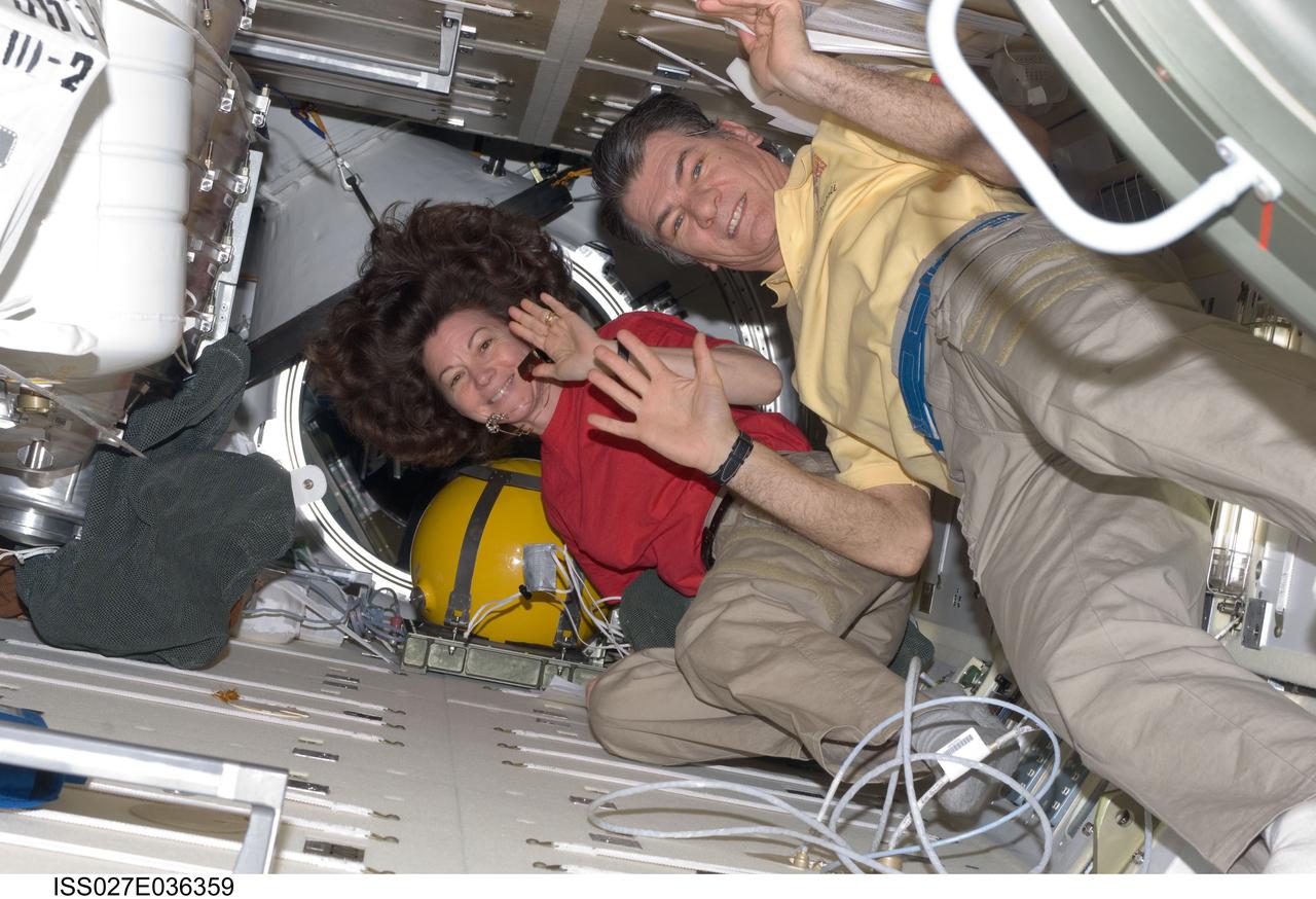 ISS027-E-036359 (23 May 2011) --- NASA astronaut Cady Coleman and European Space Agency astronaut Paolo Nespoli, both Expedition 27 flight engineers, wave as they make preparations to board the Soyuz TMA-20 spacecraft that will return them, along with Russian cosmonaut Dmitry Kondratyev (out of frame), commander, to Earth. The Soyuz undocked at 5:35 p.m. (EDT) from the International Space Station’s Rassvet module. The crew landed safely at 10:27 p.m. southeast of the town of Dzhezkazgan, Kazakhstan.