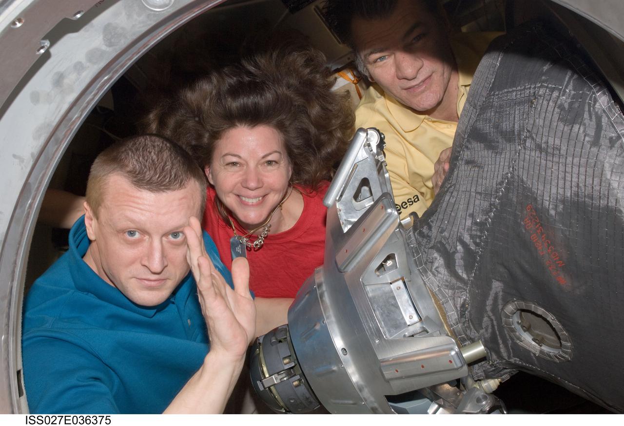 ISS027-E-036375 (23 May 2011) --- Russian cosmonaut Dmitry Kondratyev (left), Expedition 27 commander; NASA astronaut Cady Coleman and European Space Agency astronaut Paolo Nespoli, both flight engineers, pause for a photo while closing the hatch to the Soyuz TMA-20 spacecraft that will return them to Earth. The Soyuz undocked from the International Space Station’s Rassvet module at 5:35 p.m. (EDT) on May 23, 2011. The crew landed safely at 10:27 p.m. southeast of the town of Dzhezkazgan, Kazakhstan.