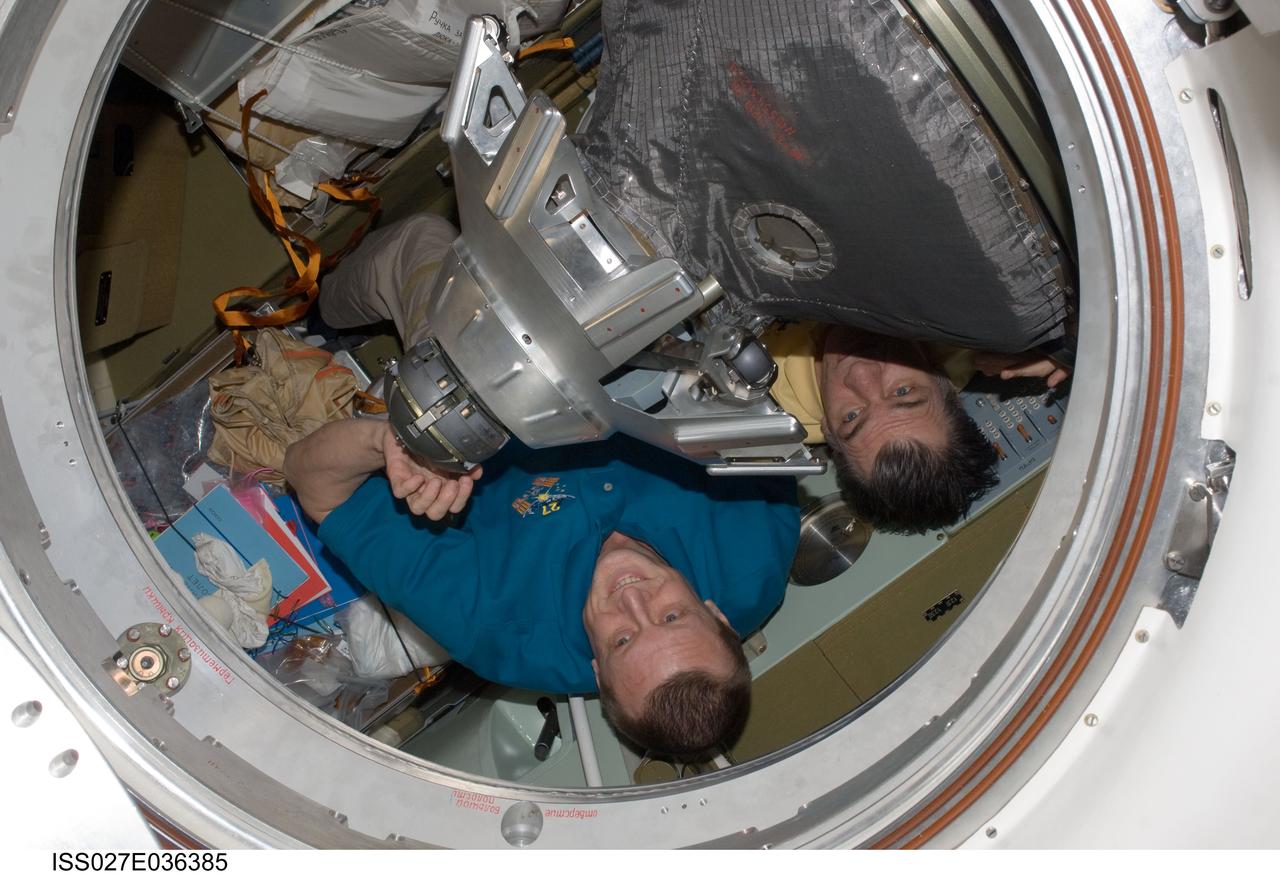ISS027-E-036385 (23 May 2011) --- Russian cosmonaut Dmitry Kondratyev (left), Expedition 27 commander; European Space Agency astronaut Paolo Nespoli and NASA astronaut Cady Coleman (obscured), both flight engineers, are pictured while closing the hatch to the Soyuz TMA-20 spacecraft that will return them to Earth. The Soyuz undocked from the International Space Station’s Rassvet module at 5:35 p.m. (EDT) on May 23, 2011. The crew landed safely at 10:27 p.m. southeast of the town of Dzhezkazgan, Kazakhstan.