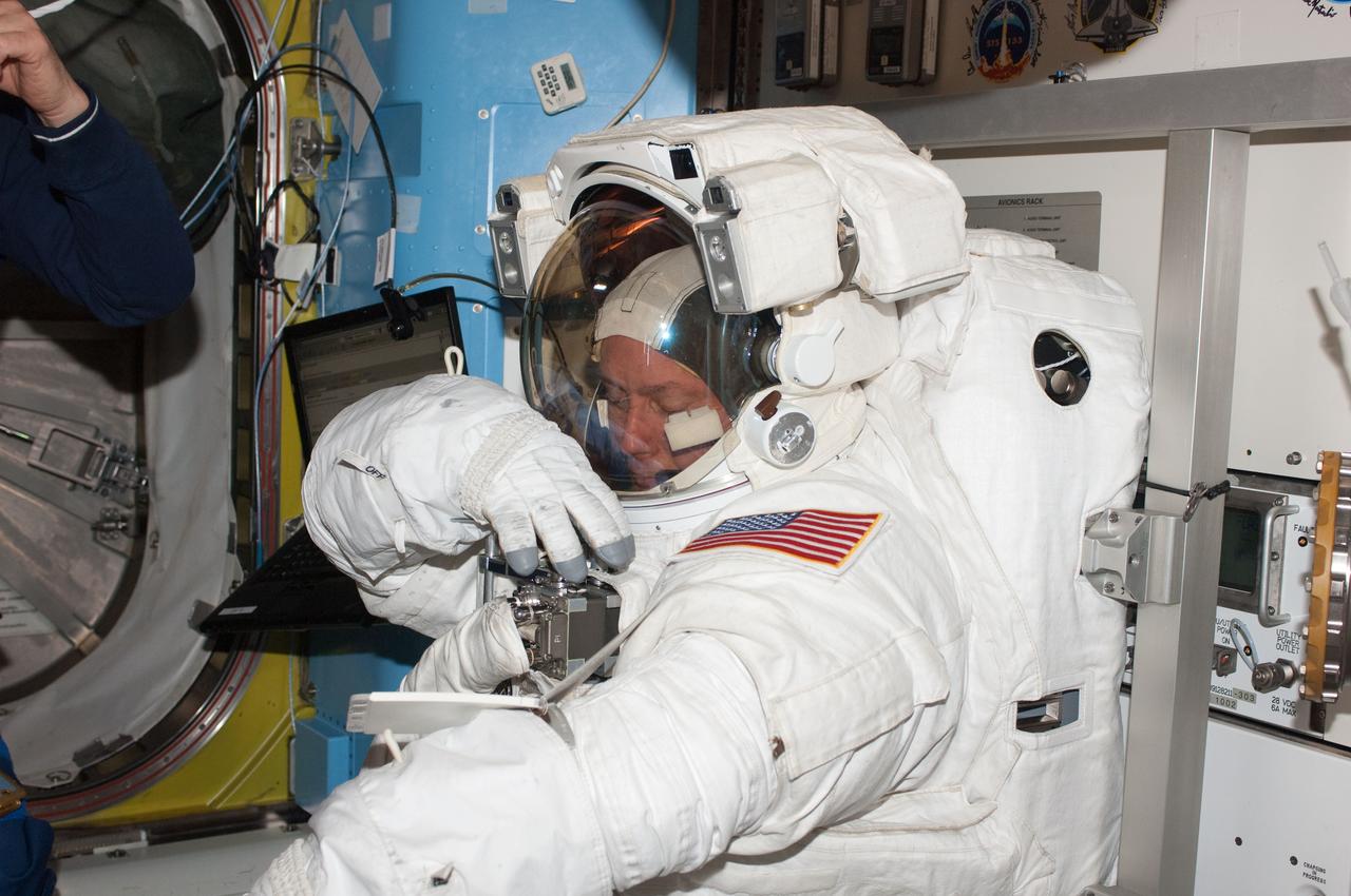 ISS028-E-005230 (25 May 2011) --- NASA astronaut Michael Fincke, STS-134 mission specialist, attired in an Extravehicular Mobility Unit (EMU) spacesuit, prepares for the start of the mission?s third session of extravehicular activity (EVA) in the Quest airlock of the International Space Station.
