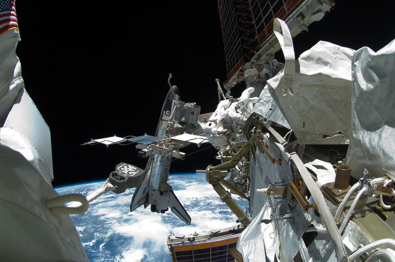 ISS028-E-005634 (27 May 2011) --- A fish-eye lens attached to an electronic still camera was used to capture this image of NASA astronaut Michael Fincke (top center) during the mission's fourth session of extravehicular activity (EVA) as construction and maintenance continue on the International Space Station. During the seven-hour, 24-minute spacewalk, Fincke and astronaut Greg Chamitoff (out of frame), both STS-134 mission specialists, completed the primary objectives for the spacewalk, including stowing the 50-foot-long boom and adding a power and data grapple fixture to make it the Enhanced International Space Station Boom Assembly, available to extend the reach of the space station's robotic arm. The docked space shuttle Endeavour is visible at left. The blackness of space and Earth?s horizon provide the backdrop for the scene.